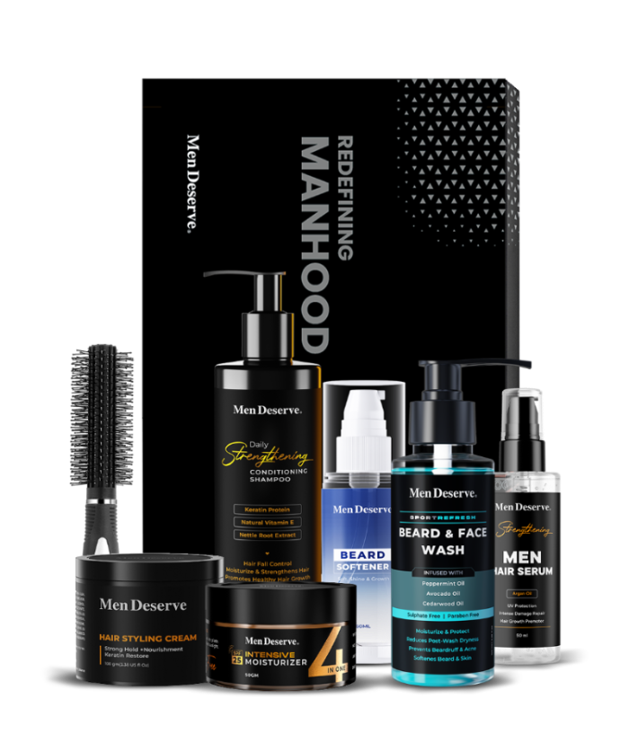 A collection of men's grooming products including beard and face wash, hair shampoo, hair styling cream, intensive moisturizer, serum, and a round hair brush, all packaged in a branded box.