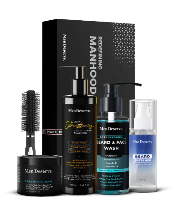 A Men Grooming Kit containing shampoo, hair cream, beard and face wash, beard softener, and a round hair brush, all displayed in front of a black box with the text 'Men Deserve'.