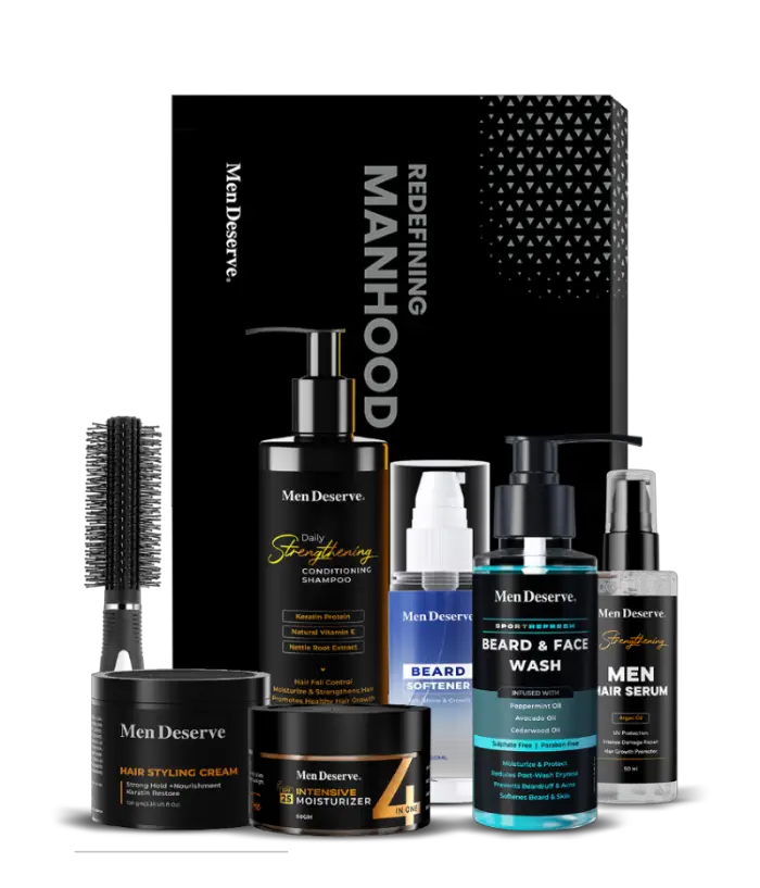 A collection of men's grooming products including beard and face wash, hair shampoo, hair styling cream, intensive moisturizer, serum, and a round hair brush, all packaged in a branded box.