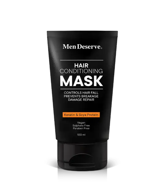 A black tube of MenDeserve hair conditioning mask with white and orange text highlighting the product's benefits like controlling hair fall, nourishing, and promoting hair growth.