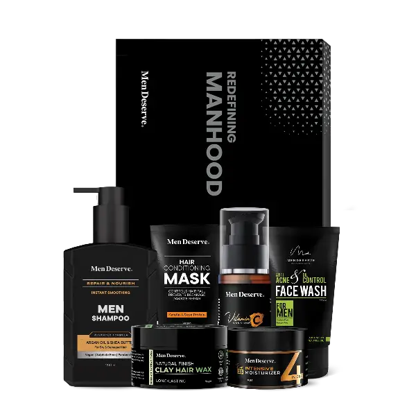A Men's grooming kit including various hair and face care products such as shampoo, conditioner, face wash, and a grooming spray, packaged in black bottles and containers with the brand 'Men Deserve' displayed.